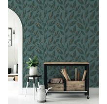Vliesbehang met bladmotief in een modern ingerichte woonruimte met houten meubels en kamerplant.
