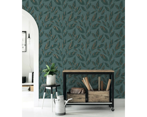 Vliesbehang met bladmotief in een modern ingerichte woonruimte met houten meubels en kamerplant.