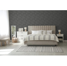 Moderne slaapkamer met grijs patroonbehang, beige gestoffeerd bed, witte commode en lichte vloer met gestreept tapijt.