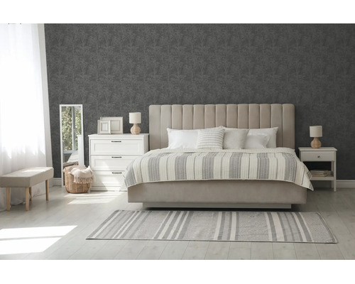 Moderne slaapkamer met grijs patroonbehang, beige gestoffeerd bed, witte commode en lichte vloer met gestreept tapijt.