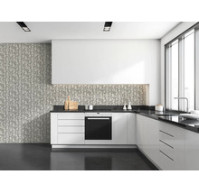Moderne keuken met witte kasten, donker werkblad en behang met takkenpatroon als spatwand en op de muur.