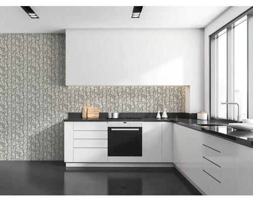 Moderne keuken met witte kasten, donker werkblad en behang met takkenpatroon als spatwand en op de muur.