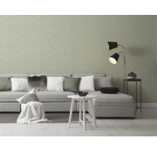 Moderne woonkamer met lichtgroen behang met takpatroon, grijze hoekbank, witte bijzettafel en een tweelamps vloerlamp.