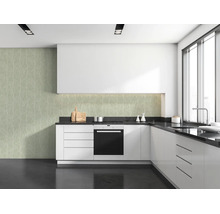Moderne L-vormige keuken met witte kasten, donker werkblad en vliesbehang met boommotief als achterwand.