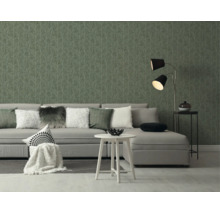 Moderne woonkamer met grijze bank, witte bijzettafel en behang met subtiel takkenpatroon.