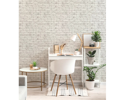 Moderne werkplek met behang in baksteenlook, wit bureau, stoel en rek met groene planten. Licht en georganiseerd kamerontwerp.