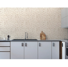Vliesbehang met steenlook op een keukenmuur in een lichte, modern ingerichte keuken met gootsteen.