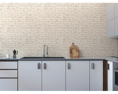 Vliesbehang met steenlook op een keukenmuur in een lichte, modern ingerichte keuken met gootsteen.