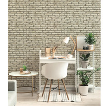 Helder ingerichte werkplek met baksteenlook behang, een wit bureau met stoel en een stellingkast met groene planten.