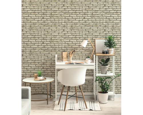 Helder ingerichte werkplek met baksteenlook behang, een wit bureau met stoel en een stellingkast met groene planten.