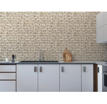 Moderne keuken met behang in lichte baksteenlook, witte onderkasten en een gootsteen.