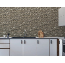 Vliesbehang met steenlook op een keukenmuur boven een wit keukenblok met spoelbak.