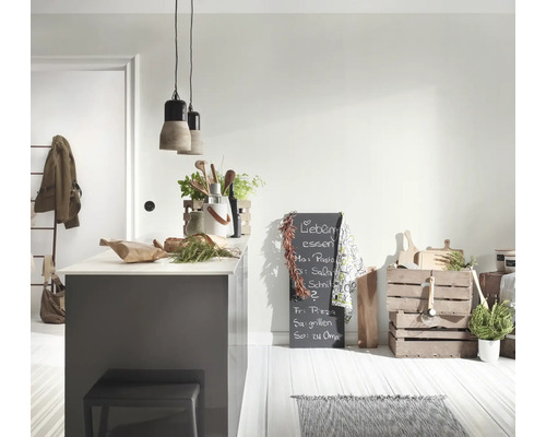 Lichte, moderne keuken met grijs kookeiland, twee betonnen hanglampen, houten kisten voor opslag en een beschreven krijtbord.