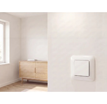 Moderne lichtschakelaar op een muur in een lichte, minimalistische kamer met een houten dressoir en raam.