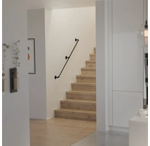 Moderne trap met houten treden en een wandleuning in industrieel design van metalen buizen.