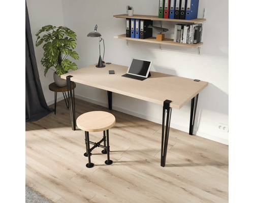 Moderne werkplek met houten bureau, zwarte metalen poten, bijpassende kruk in industrieel ontwerp en wandplanken.