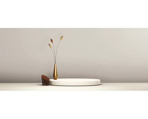 Minimalistische scène met wit rond podium, smalle goudkleurige vaas met siertakken en een kleine bruine kruk.