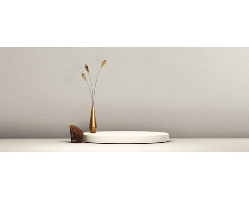 Lichtbeige behang met fijne structuur in een minimalistische kamer met podium en decoratieve vaas.