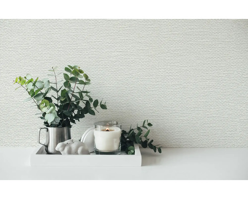 Behang met horizontale structuur achter een decoratief dienblad met eucalyptustakken en een brandende kaars.