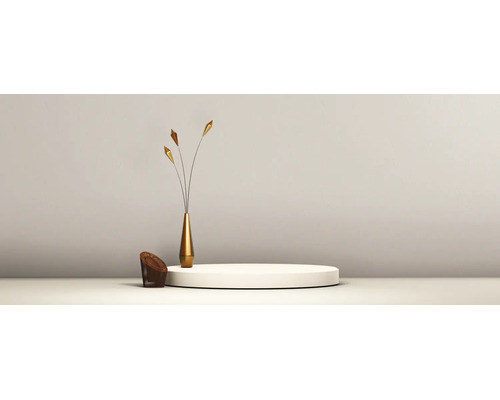 Minimalistische inrichting met een rond wit podium, een slanke gouden vaas met decoratieve stelen en een klein gevlochten element.