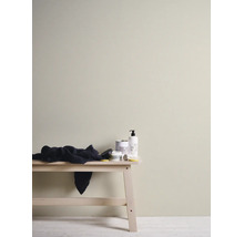 Binnenmuur geschilderd in een lichte beige kleur, minimalistische opstelling met houten bank en verzorgingsproducten.
