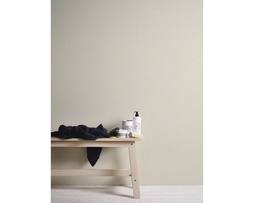 Binnenmuur geschilderd in een lichte beige kleur, minimalistische opstelling met houten bank en verzorgingsproducten.