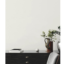 Heldere minimalistische scène met een lichtgekleurde muur, een donker houten bureau met decoratie, boeken en een plant in een vaas.