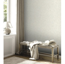 Behang met textuur in een lichte kamer met een houten bank, een gordijn en een tafellamp.