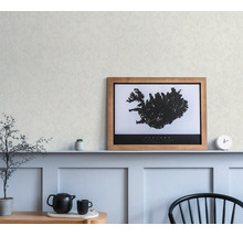 Ingelijste kaart van IJsland in een houten lijst, op een plank boven wandpanelen in een lichte, modern ingerichte kamer.