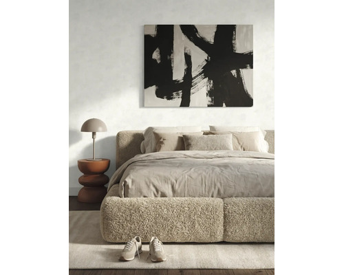 Moderne slaapkamer met bedframe van bouclé stof, beddengoed in natuurtinten, een abstract schilderij en een paddenstoelvormige lamp.
