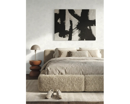 Moderne slaapkamer met pluizig gestoffeerd bed, abstract schilderij, sculpturale bijzettafel en tafellamp in een licht, minimalistisch ontwerp.