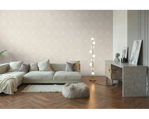 Lichte woonkamer met behang met subtiel patroon, lichte bank, moderne vloerlamp en visgraatparket.