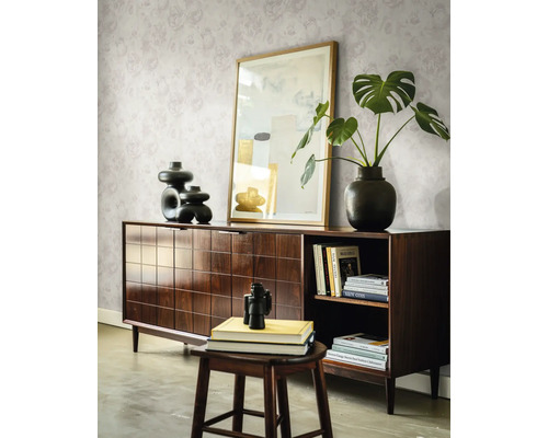 Donkerhouten dressoir met ruitjespatroon, gedecoreerd met vazen en een plant voor een muur met bloemenbehang in een lichte kamer.