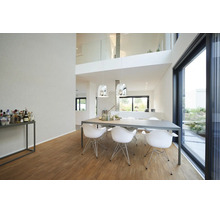 Moderne, lichte eetkamer met grijze eettafel, witte kuipstoelen, zilveren hanglampen en houten parketvloer.