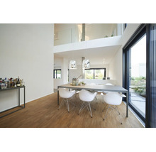Moderne, lichte eetkamer met grote eettafel, zes witte stoelen, zilveren hanglampen, houten parketvloer en grote glazen schuifdeur.