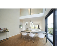 Moderne lichte eetkamer met grote grijze tafel, witte designstoelen, chromen hanglampen en houten vloer bij een glazen schuifpui.