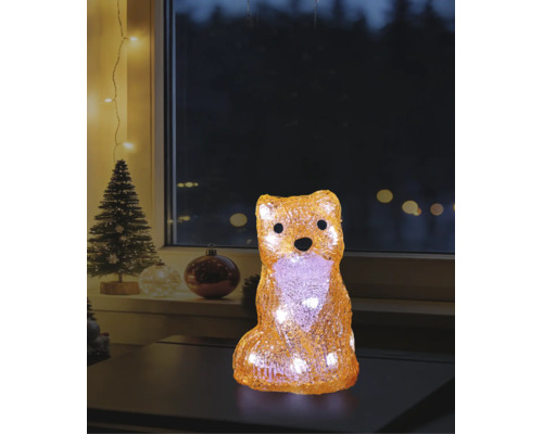 LED-decoratiefiguur vos van acryl met warmwit licht in een kerstsfeer op een tafel voor een raam.