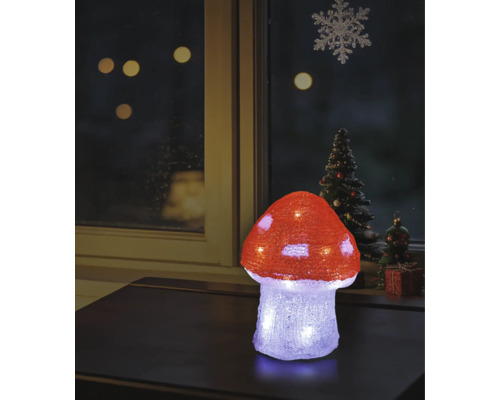 Verlichte LED-decoratie vliegenzwam van acryl op een tafel, kerstvensterdecoratie op de achtergrond.