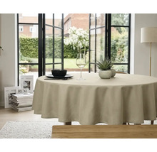 Rond beige tafelkleed op een eettafel in een lichte kamer met uitzicht op een tuin door grote ramen.