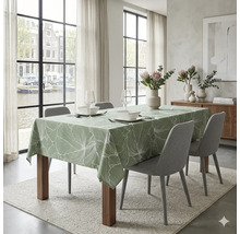 Gedekte eettafel met een tafelkleed met botanisch bladpatroon, gestoffeerde stoelen en decoratie in een lichte, moderne eetkamer.