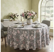 Ronde eettafel met gebloemd tafelkleed, vaas met bloemen, servies en grijze gestoffeerde stoelen in een lichte, georganiseerde eetkamer.