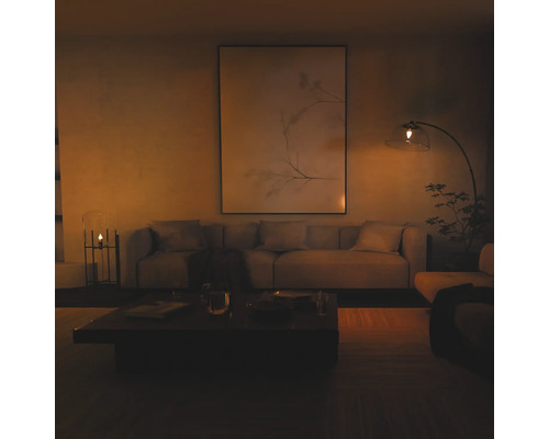 Moderne woonkamer met een grote wanddecoratie, stoffen bank en een booglamp met glazen kap in een warme, gedimde sfeer.