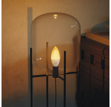 Philips Hue slimme LED kaarslamp in een moderne lamp met glazen kap en zwart metalen onderstel.