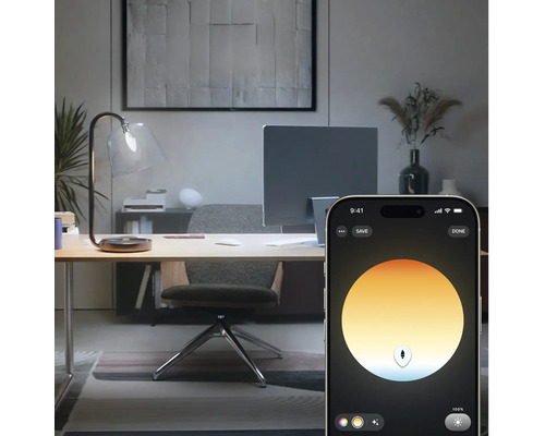 Slimme lichtregeling van een bureaulamp via een smartphone-app in een modern ingericht thuiskantoor.