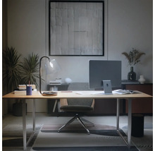 Modern thuiskantoor met licht houten bureau, monitor, glazen bureaulamp en ergonomische bureaustoel in een opgeruimde sfeer.