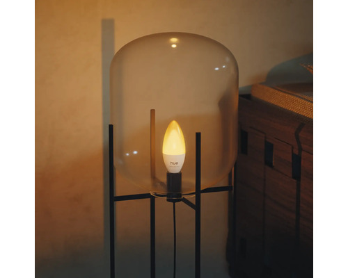 Philips Hue slimme LED kaarslamp in een moderne lamp met glazen kap en zwart metalen onderstel.