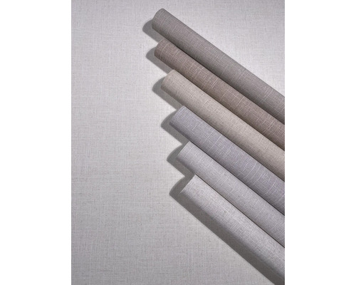 Meerdere rollen vliesbehang met linnenlook in verschillende neutrale tinten.