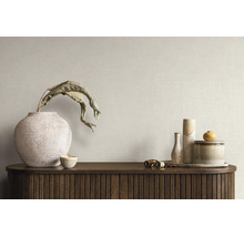Licht interieur met licht gestructureerd behang, een dressoir van donker hout en diverse decoratieve vazen van keramiek.