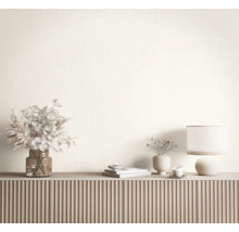 Modern dressoir met een geribbelde voorkant, gedecoreerd met een glazen vaas met droogbloemen, een tafellamp en keramische decoraties.