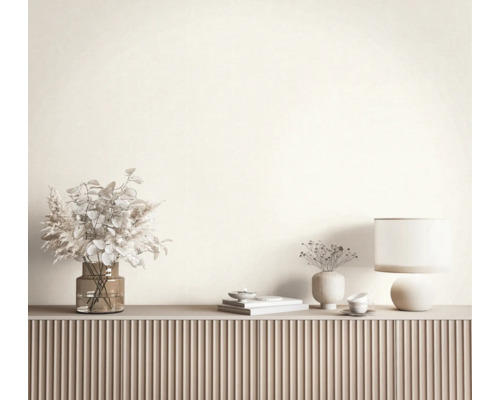 Modern dressoir met een geribbelde voorkant, gedecoreerd met een glazen vaas met droogbloemen, een tafellamp en keramische decoraties.
